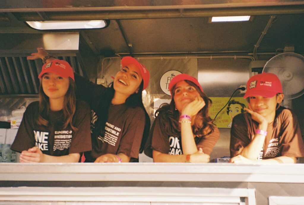4 tjejer i merch ifrån One Cake i deras foodtruck på musikfestivalen Lollapalooza i Stockholm sommaren 2021. 